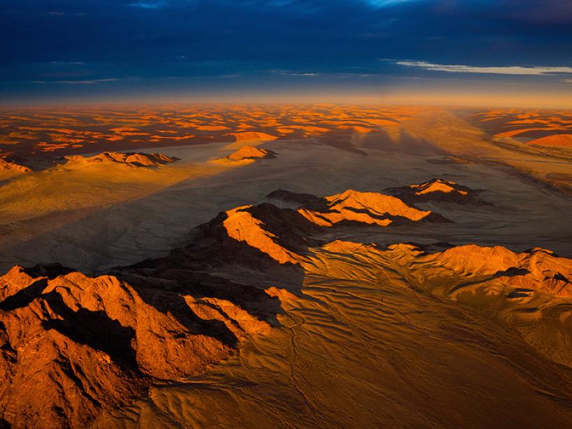 Admire the pink and orange tones of the sand dunes covering the Namib desert in Sossusvlei