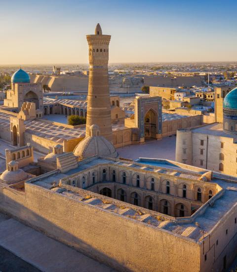 Sunset over the famous Kalyan Poi Kalon Minaret, Poi Kalan or Po-i-Kalyan and Mir Arab Madrasah in the center of the old town of Bukhara