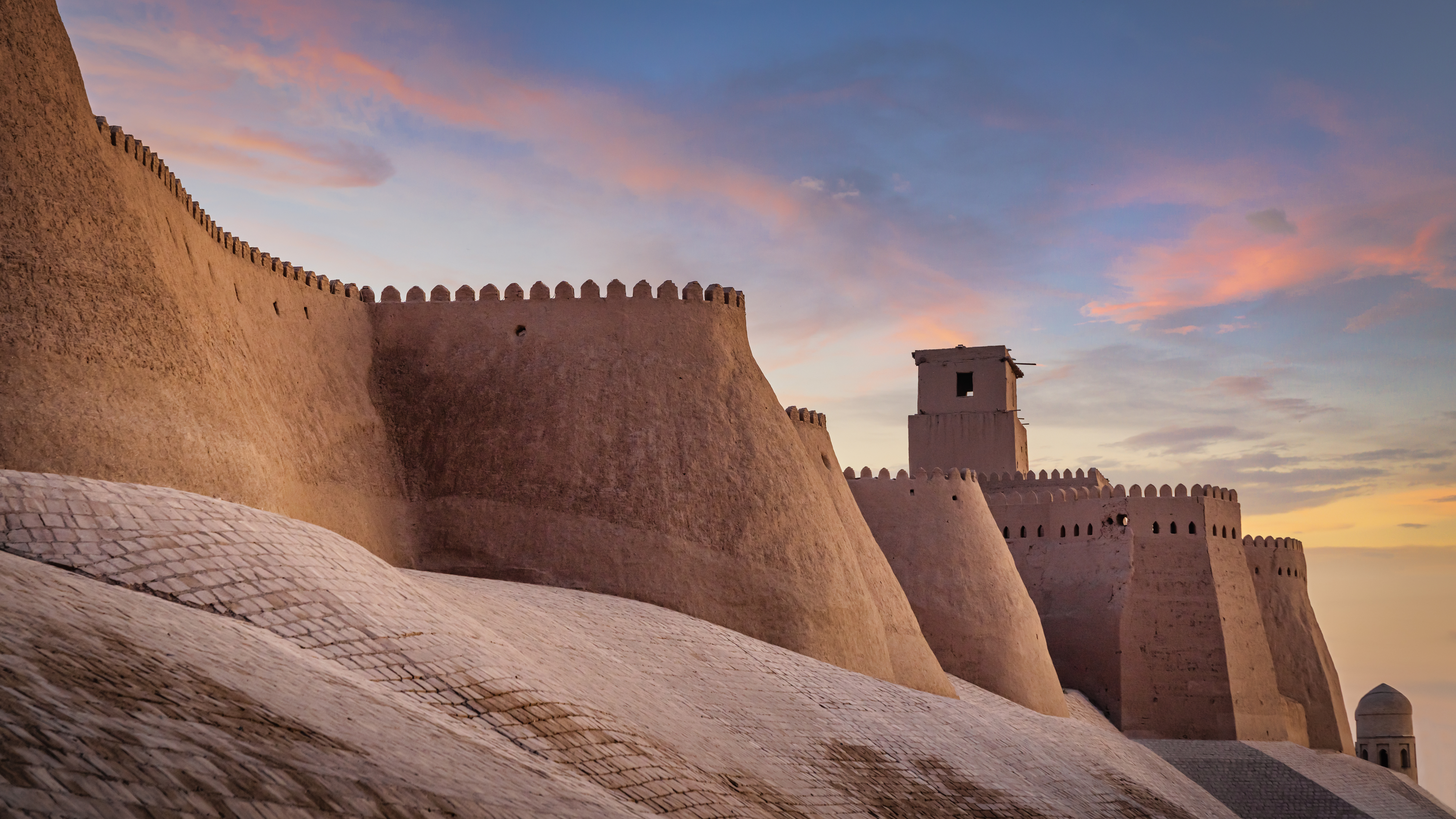 Majestic ancient historic city walls of the old town of Khiva under beautiful colorful sunset twilight. Ancient City Walls Khiva, Itchan Kala, Khiva - Chiva - Хива, Xorazm Region, Uzbekistan