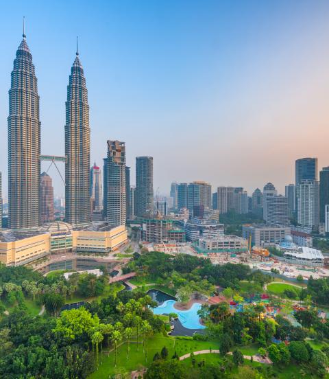 Sunset skyline view of Kuala Lumpur featuring the Petronas Twin Towers, an interlinked pair of 88-storey skyscrapers 