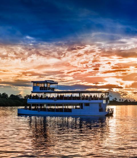 Picturesque sunset landscape with the riverboat at Zambezi river