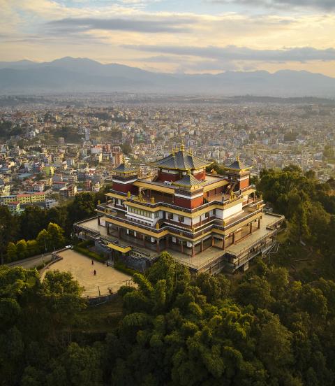 "Pullahari Monastery, Buddhist pilgrimage site on northern hill in Kathmandu Valley with city and mountains in background. "