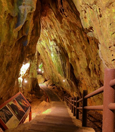 Stairs descend underneath natural rock and caves