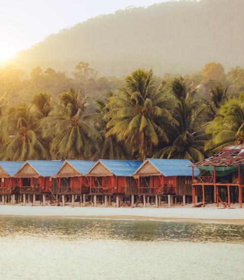 Elevated bungalows along beach with lush palm trees on the secluded Island Koh Rong Sanloem, Sihanoukville Province, Cambodia