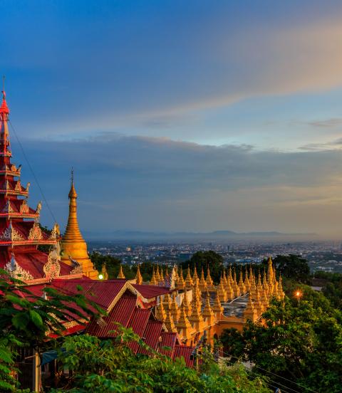 HIllside view of the red roof of Mandalay Palace and Hill