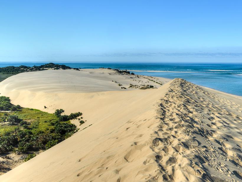 Hike the soft sand dunes of Mozambique for a breathtaking view of the water